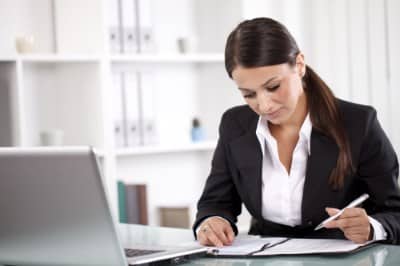 Lady working on a surety bond quote - lady computer with white background